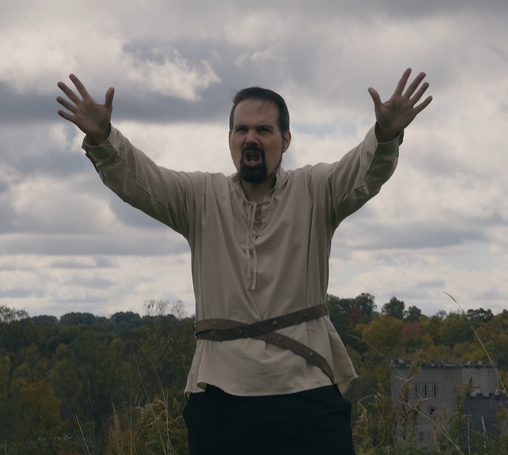 Dustin Wray performing outdoors with arms raised